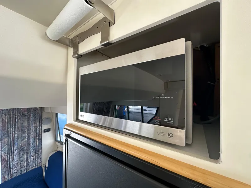 Slide: The Image of Microwave in 1996 Carver Voyager interior, above a compact refrigerator. - 33