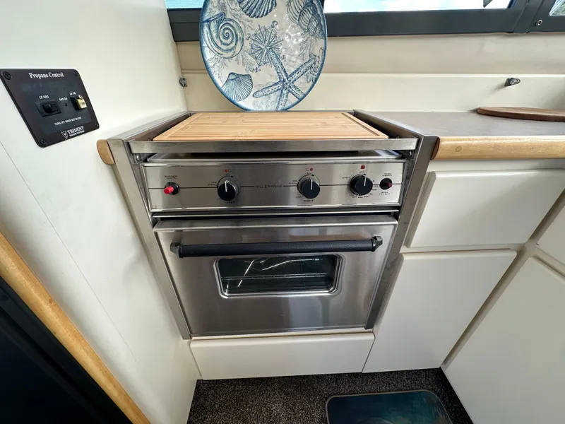 Slide: The Image of 1996 Carver Voyager kitchen with stainless steel oven and decorative plate. - 34