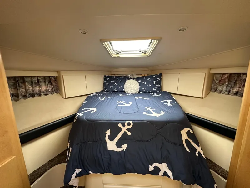 Slide: The Image of 1996 Carver Voyager cabin with anchor-themed bedding and overhead skylight. - 38
