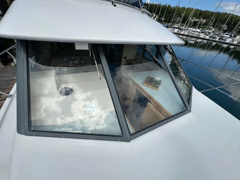 Slide: The Image of 1996 Carver Voyager yacht with reflective windows docked at a marina. - 4