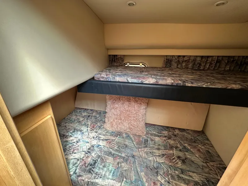 Slide: The Image of 1996 Carver Voyager cabin interior with patterned bedding and wood accents. - 43