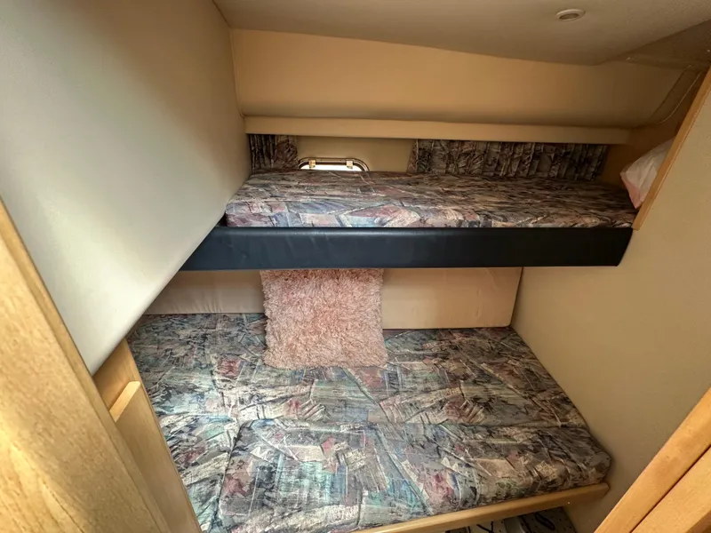 Slide: The Image of 1996 Carver Voyager cabin with bunk beds and patterned bedding. - 44