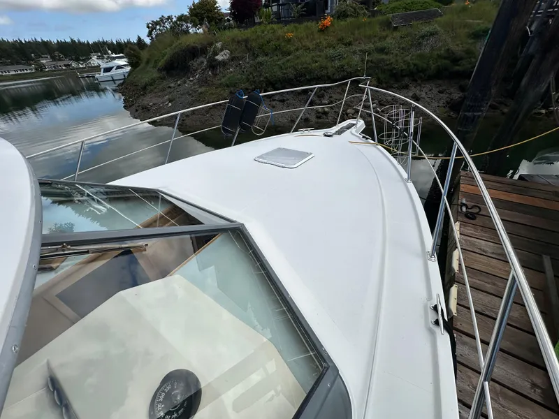 Slide: The Image of 1996 Carver Voyager boat docked by a scenic shoreline. - 5