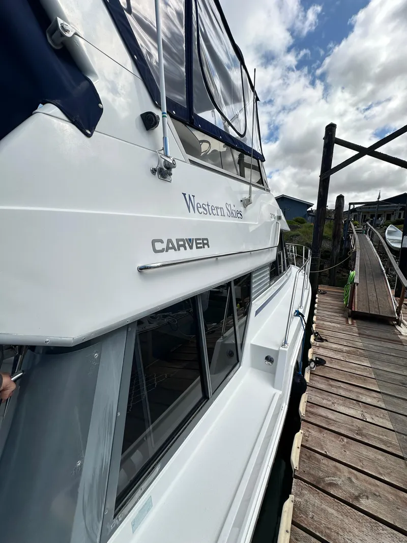 Slide: The Image of 1996 Carver Voyager boat docked, featuring sleek design and "Western Skies" name. - 7