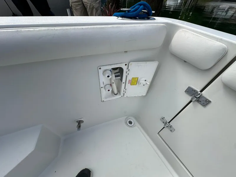 Slide: The Image of 1996 Carver Voyager boat interior with storage compartment and white seating. - 9