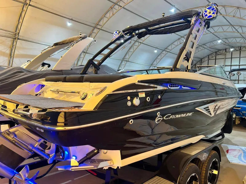 Slide: The Image of 2024 Crownline 240SS Surf boat in showroom, featuring sleek design and modern amenities. - 1
