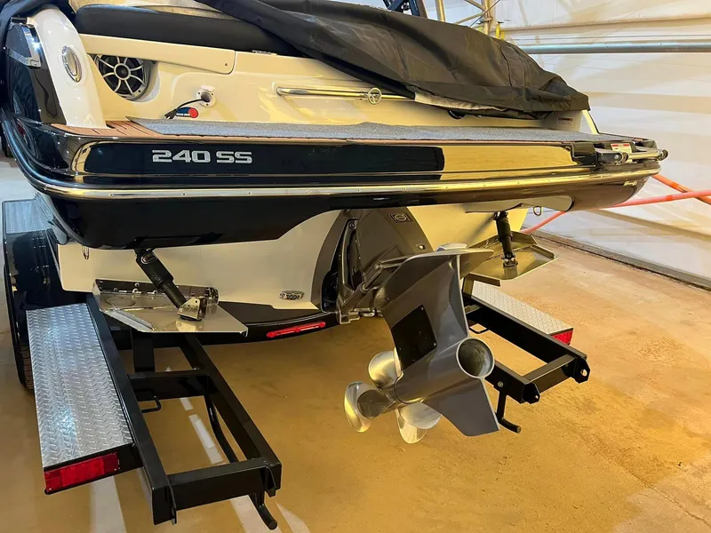 Slide: The Image of 2024 Crownline 240SS Surf boat on trailer, rear view showing propeller and hull details. - 10