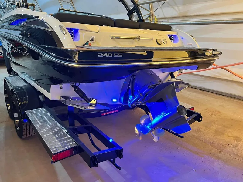 Slide: The Image of 2024 Crownline 240SS Surf boat on trailer, featuring sleek design and illuminated propeller. - 7