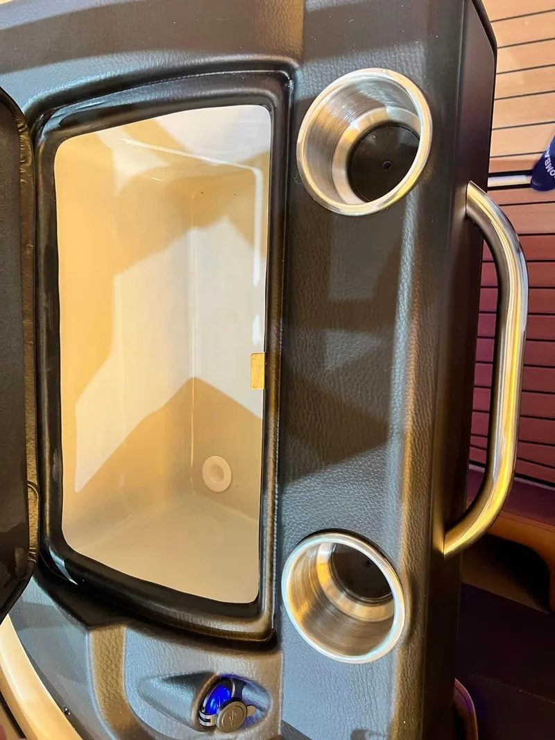 Slide: The Image of 2024 Crownline 240SS Surf boat interior with cup holders and storage compartment. - 9