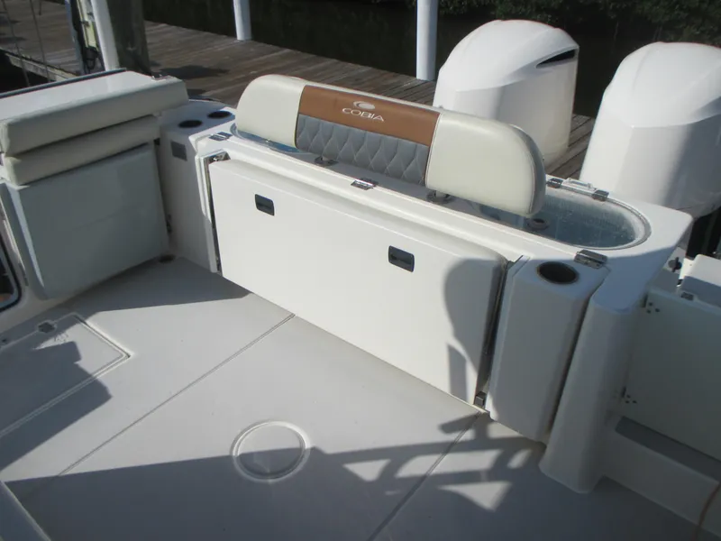 Slide: The Image of 2018 Cobia 301 Center Console boat interior with storage compartments and rod holders. - 11