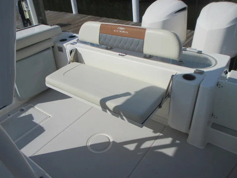 Slide: The Image of 2018 Cobia 301 Center Console boat interior with open transom door at dock. - 12