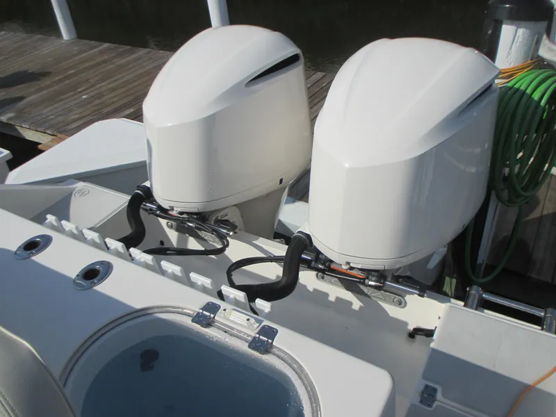 Slide: The Image of 2018 Cobia 301 Center Console boat docked with fishing rods and twin engines. - 5