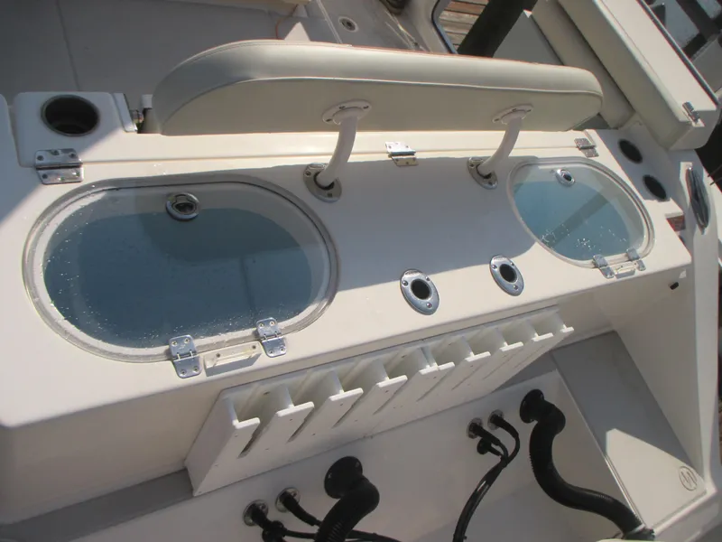 Slide: The Image of 2018 Cobia 301 Center Console boat with dual outboard engines docked. - 6