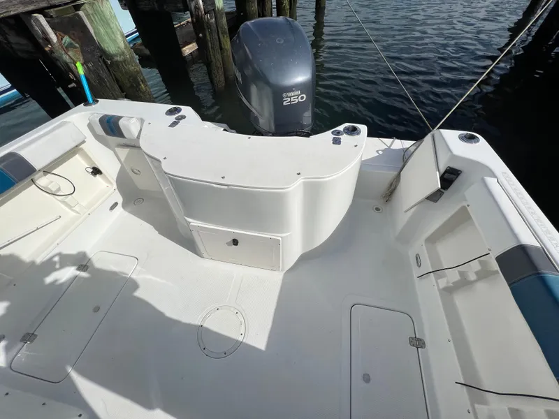Slide: The Image of 2005 Sailfish 234 WAC boat deck with Yamaha 250 engine, docked by wooden piers. - 26