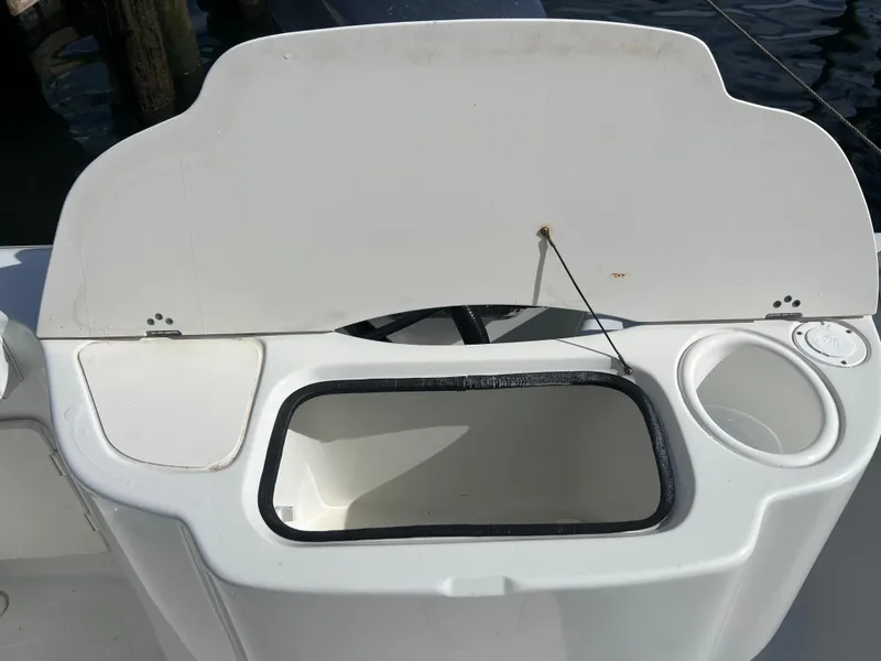 Slide: The Image of 2005 Sailfish 234 WAC boat storage compartment with open lid and cup holder. - 27