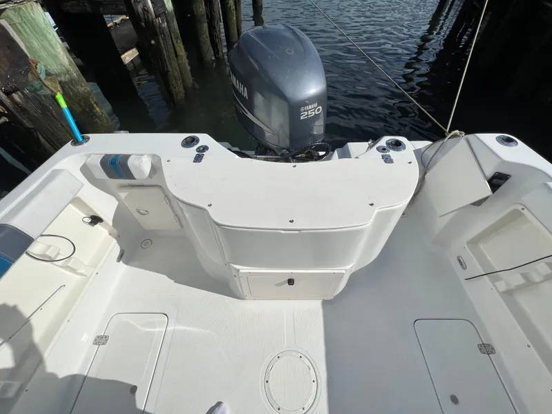 Slide: The Image of 2005 Sailfish 234 WAC boat deck with Yamaha 250 engine, docked by wooden pilings. - 28