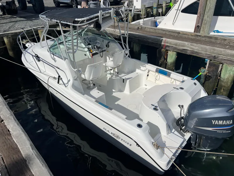 Slide: The Image of 2005 Sailfish 234 WAC boat docked, featuring Yamaha outboard motor and spacious cockpit. - 3