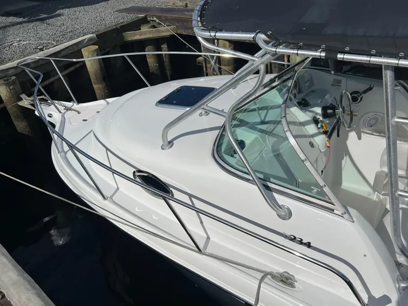 Slide: The Image of 2005 Sailfish 234 WAC boat docked, featuring sleek design and spacious cockpit. - 4