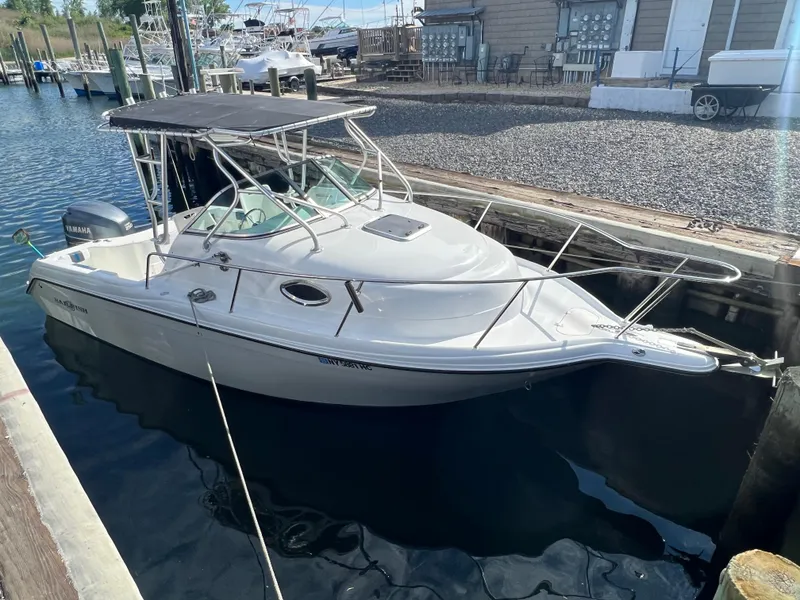 Slide: The Image of 2005 Sailfish 234 WAC boat docked at marina, featuring sleek design and Yamaha engine. - 6
