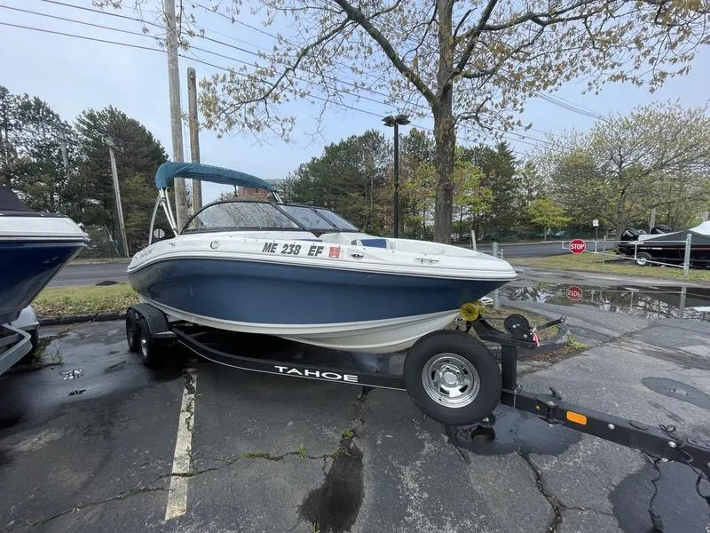 Slide: The Image of 2019 Tahoe 500 TS boat on trailer in parking lot, surrounded by trees. - 8
