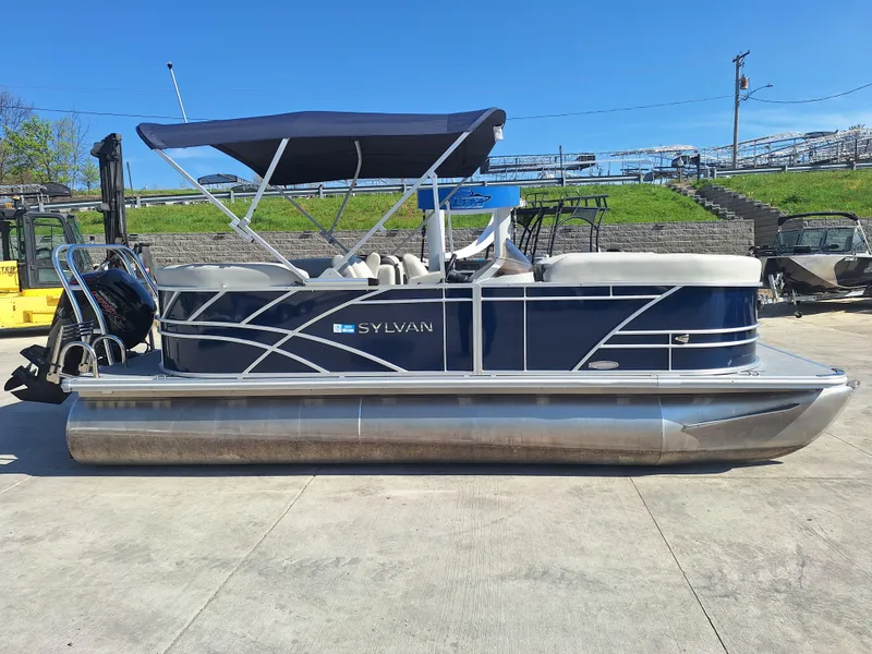 Slide: The Image of 2024 Sylvan Mirage Cruise 8520 CLZ DH pontoon boat with canopy, parked on concrete. - 1