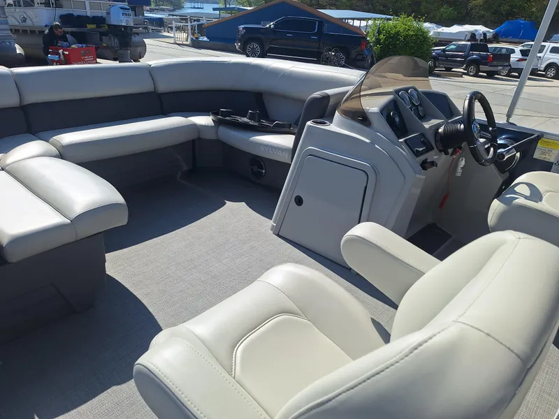 Slide: The Image of 2024 Sylvan Mirage Cruise 8520 CLZ DH pontoon boat interior with plush seating and helm. - 16