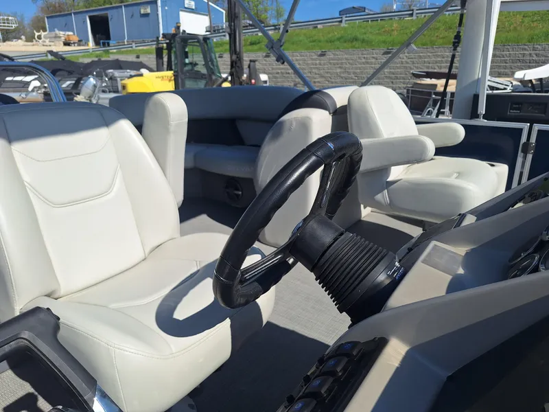 Slide: The Image of 2024 Sylvan Mirage Cruise 8520 CLZ DH boat interior with steering wheel and seating. - 9