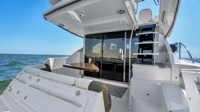 Slide: The Image of 2015 Sea Ray 510 Fly yacht, rear view, open deck, ocean backdrop. - 9