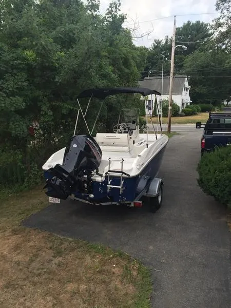 Slide: The Image of 2017 Bayliner Element F18 CC boat parked on driveway, surrounded by greenery. - 1