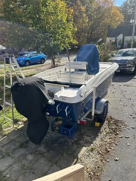 Slide: The Image of 2017 Bayliner Element F18 CC boat parked on a driveway, surrounded by trees and vehicles. - 5