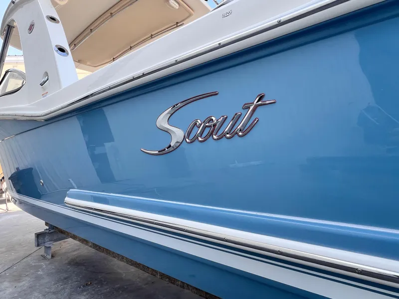 Slide: The Image of 2018 Scout 275 Dorado boat with blue hull and chrome logo. - 2