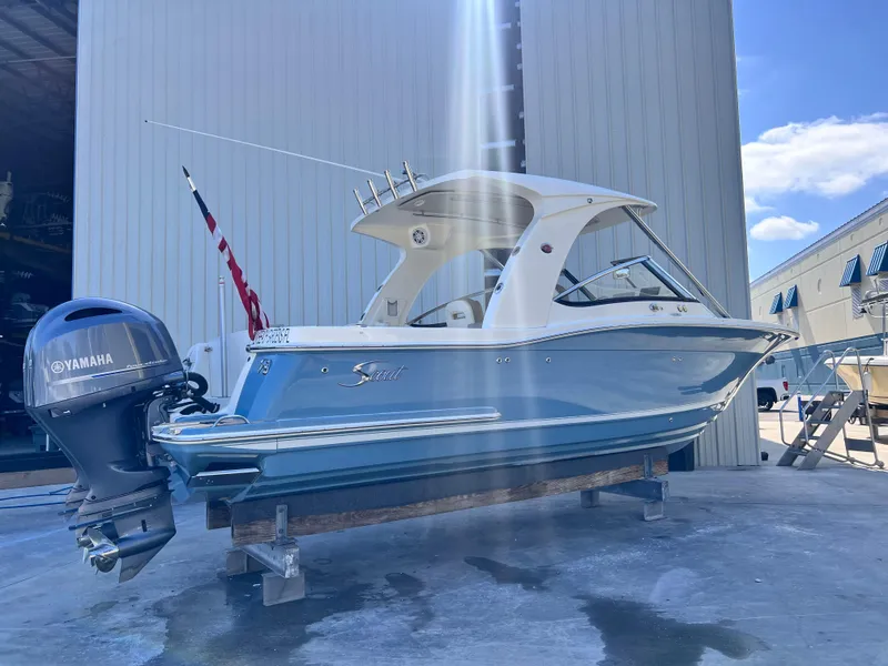 Slide: The Image of 2018 Scout 275 Dorado boat with Yamaha engine, docked outdoors under blue sky. - 3