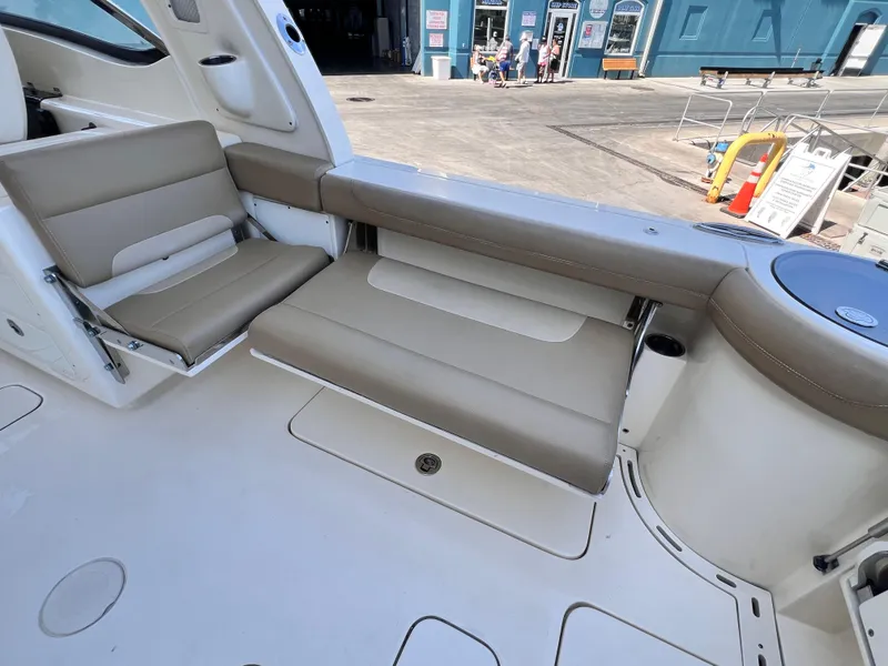 Slide: The Image of 2018 Scout 275 Dorado boat interior with beige seating and storage compartments. - 6