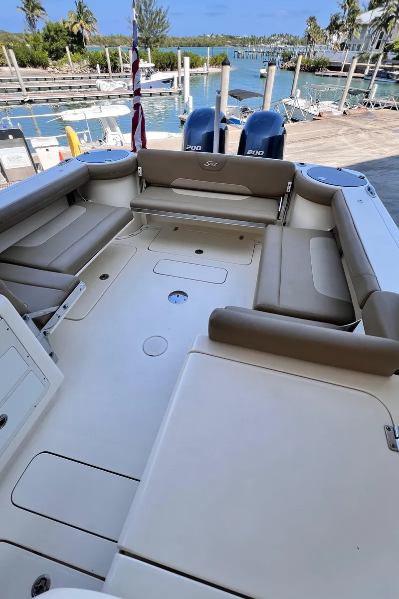 Slide: The Image of 2018 Scout 275 Dorado boat interior with spacious seating and dual outboard engines. - 9