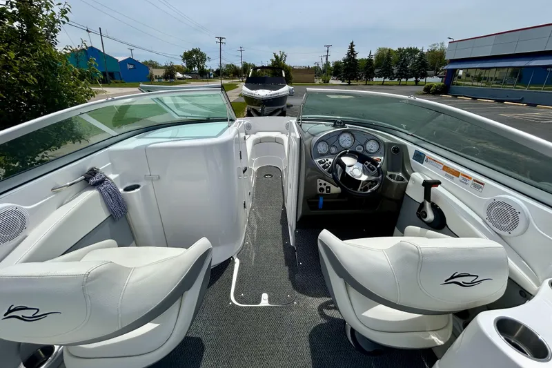 Slide: The Image of 2014 Rinker Captiva 246 BR boat interior with steering wheel and seating. - 7