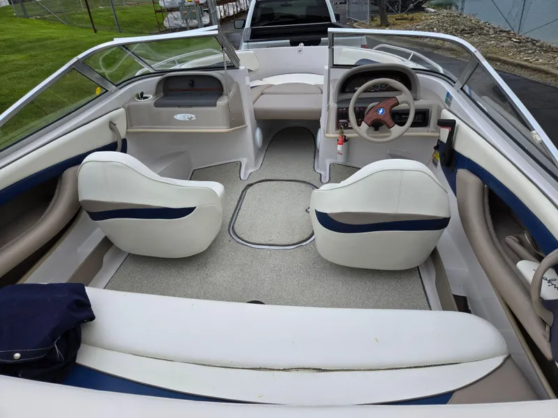 Slide: The Image of Interior of a 1998 Four Winns Horizon RS RX boat with white seating and steering wheel. - 10