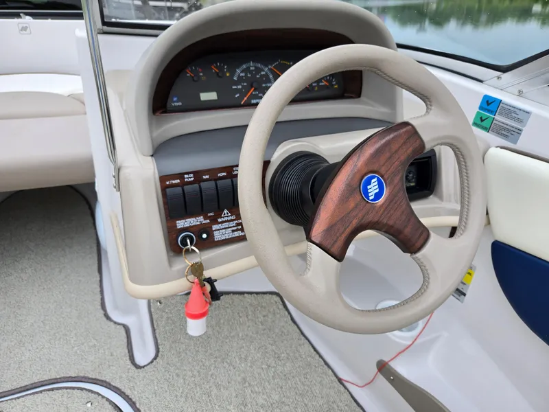 Slide: The Image of 1998 Four Winns Horizon RS RX boat dashboard with wood-accented steering wheel and instrument panel. - 12