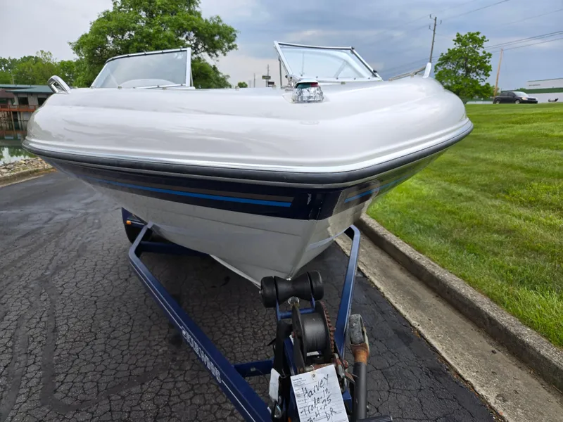 Slide: The Image of 1998 Four Winns Horizon RS RX boat on trailer, parked on paved driveway. - 6