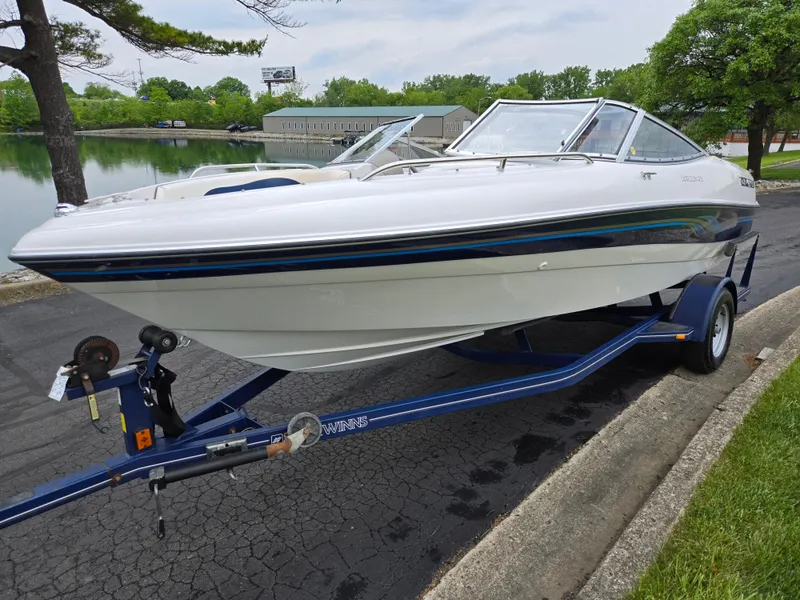 Slide: The Image of 1998 Four Winns Horizon RS RX boat on trailer by a lake. - 8