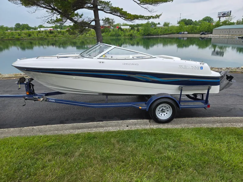 Slide: The Image of 1998 Four Winns Horizon RS RX boat on trailer by a lake. - 9
