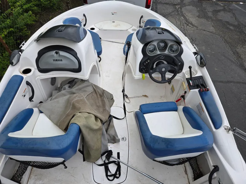 Slide: The Image of 2004 Yamaha Boats 210 LX interior with blue and white seating, steering console, and covered storage. - 16
