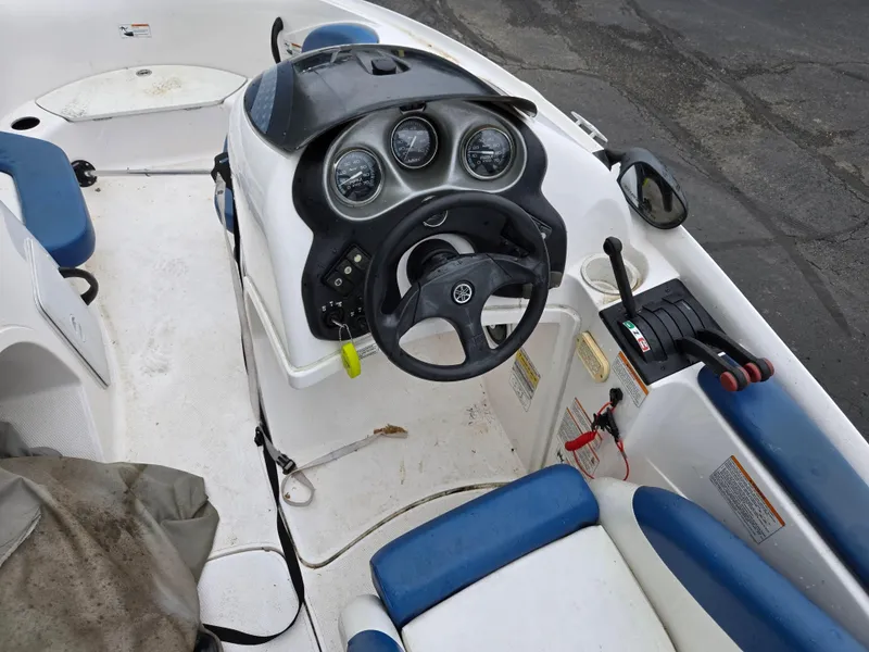 Slide: The Image of 2004 Yamaha Boats 210 LX dashboard with steering wheel and gauges, featuring blue and white seating. - 17