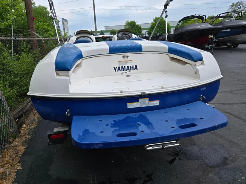 Slide: The Image of 2004 Yamaha Boats 210 LX, blue and white, rear view on pavement. - 2