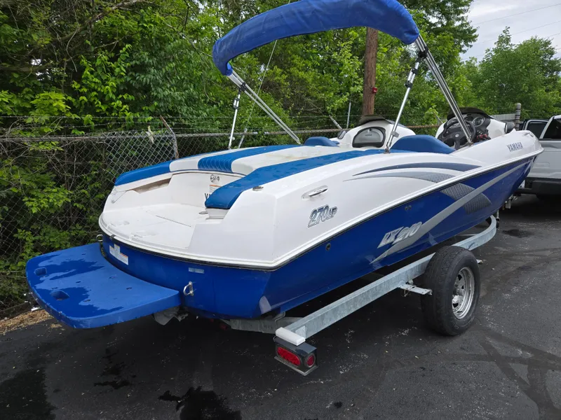 Slide: The Image of 2004 Yamaha Boats 210 LX on trailer, blue and white design, parked outdoors. - 3