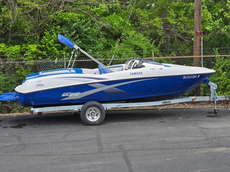 Slide: The Image of 2004 Yamaha Boats 210 LX on trailer, blue and white, parked outdoors. - 4