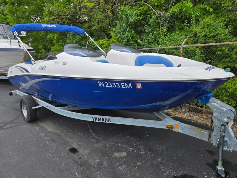 Slide: The Image of 2004 Yamaha Boats 210 LX on trailer, blue and white, parked outdoors. - 5