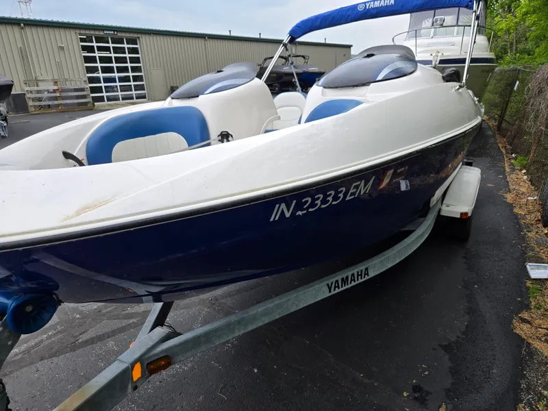 Slide: The Image of 2004 Yamaha Boats 210 LX on trailer, blue and white, parked outdoors. - 8