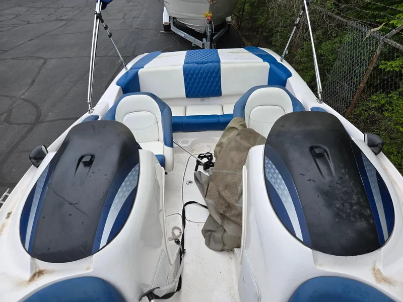 Slide: The Image of 2004 Yamaha Boats 210 LX interior with blue and white seating, parked on pavement. - 9