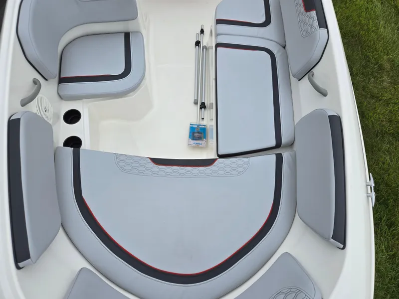Slide: The Image of 2022 Bayliner Element M15 boat interior with gray seating and cup holders. - 15