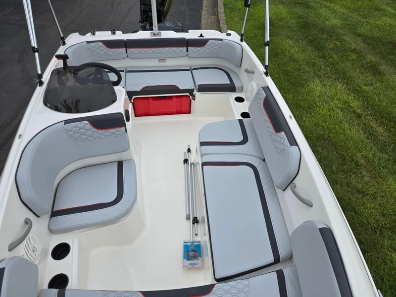 Slide: The Image of 2022 Bayliner Element M15 boat interior with gray seating and red accents. - 16